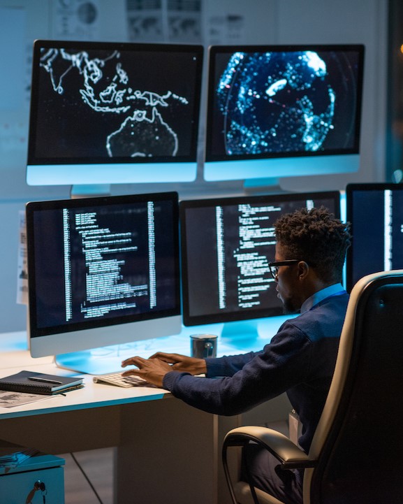 Young contemporary cyber security manager typing in front of computer Two young scientists in protective clothing look down at papers at the Business Park in Lawrence